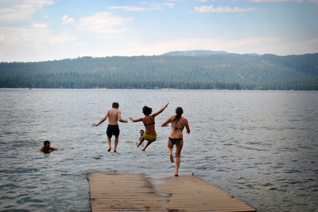 Люди прыгают в озеро с пирса