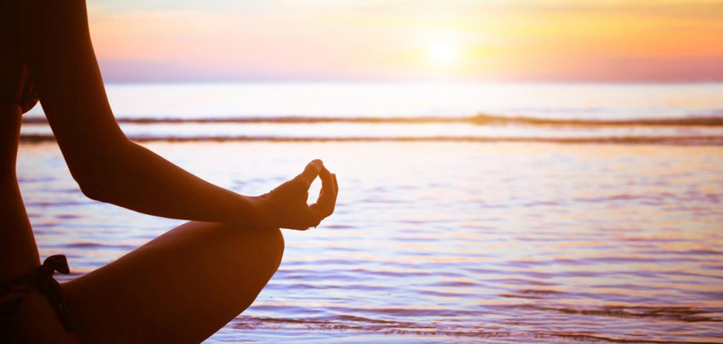 Girl meditates near the water