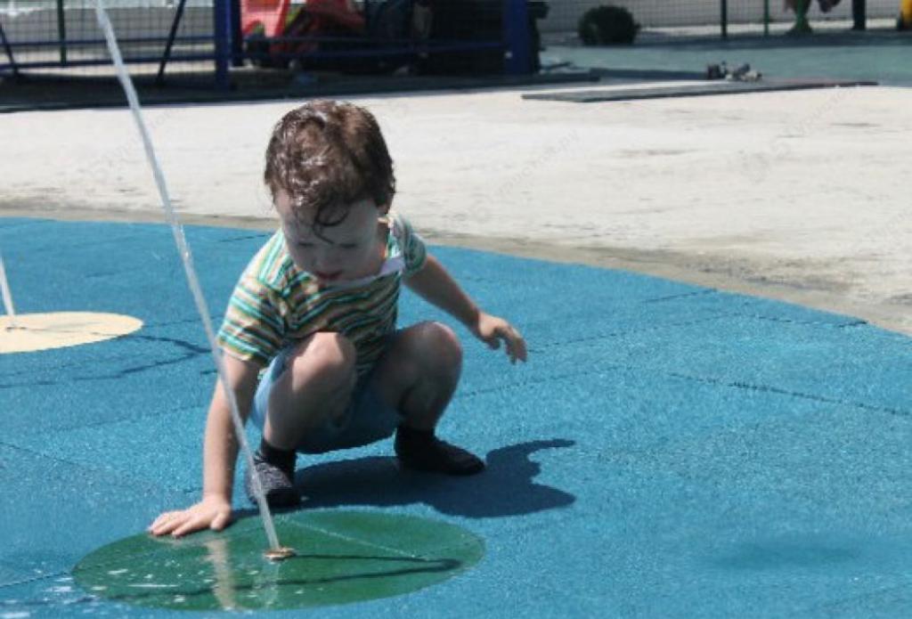 Child at the water play area in the park