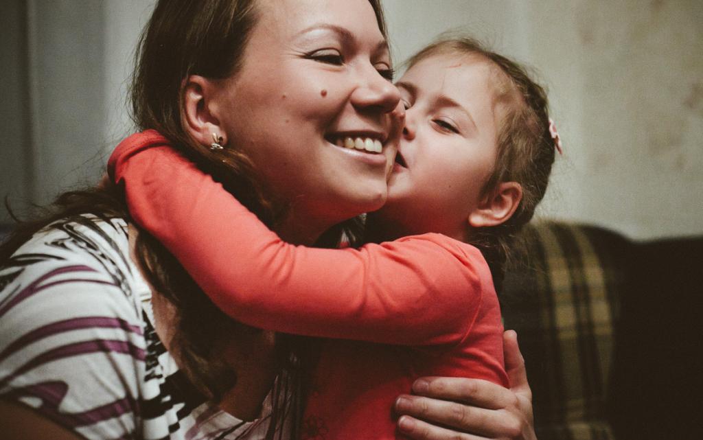 child kisses mom